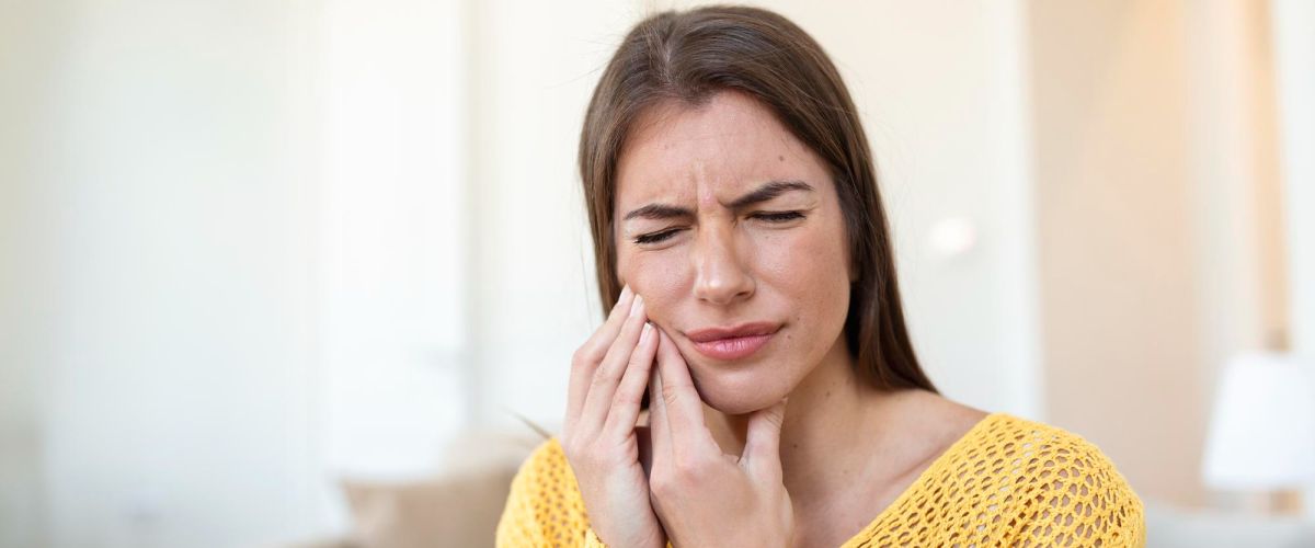 woman holding her face with toothache