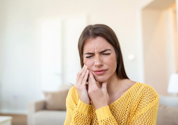woman holding her face with toothache