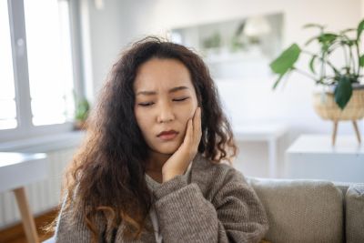 woman holding her face in pain