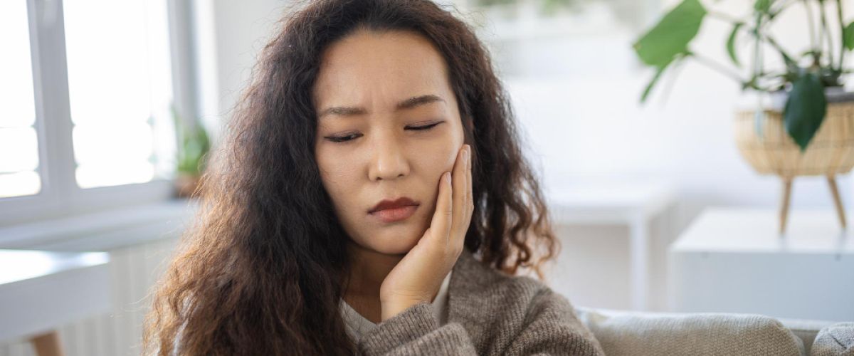 woman holding her face in pain